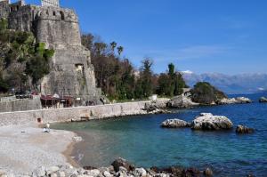 a person standing on a beach next to a body of water at Lala in Herceg-Novi