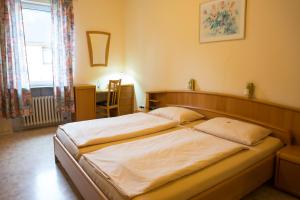 a bedroom with a large bed with white sheets at Pension bei Schinderhannes und Julchen in Boppard