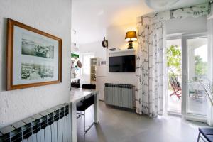 ein Wohnzimmer mit einem Tisch und einem TV im Zimmer in der Unterkunft Melanija 1 in Rovinj