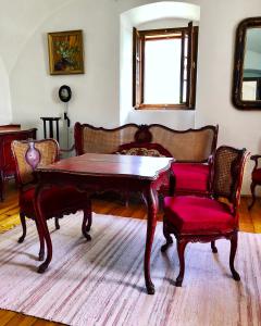 uma sala de estar com uma mesa de madeira e cadeiras em The Houses of History - anno 1830 em Tihany