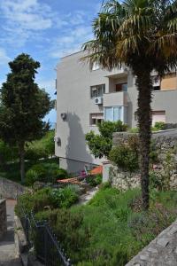 un bâtiment avec un palmier en face dans l'établissement Apartment Julia, à Split