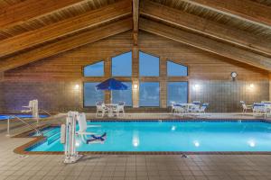 a large swimming pool in a building with windows at AmericInn by Wyndham Monroe in Monroe