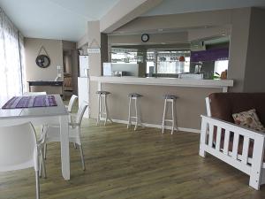 a kitchen and dining room with a table and stools at Wilderness Beach Views in Wilderness