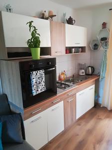 a kitchen with white cabinets and a black microwave at Apartment Ane in Bale
