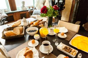 una mesa cubierta con productos para el desayuno y zumo de naranja en Guesthouse Maison de la Rose, en Brujas