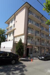 a large building with cars parked in front of it at Peshev Family Hotel Nesebar in Nesebar