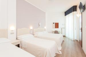 a white room with three beds in it at Hotel Roxy & Beach in Cesenatico