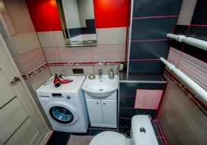 a small bathroom with a washing machine and a sink at Poruka apartamenti in Ventspils +21 photos