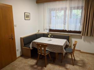 comedor con mesa, sillas y ventana en Ferienwohnung Winklerhof, en Lana