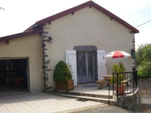 a small house with a patio with an umbrella at la grange aux créations in Mentières