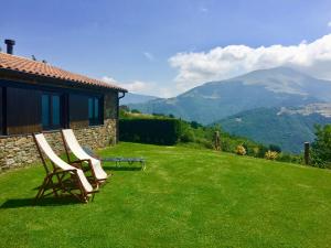 two chairs on a lawn with mountains in the background at CasaCampelles I - Vall de Núria - Ripollès in Campelles