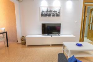un salon avec une télévision à écran plat sur une armoire blanche dans l'établissement Nations Apartment with pool, à Alicante