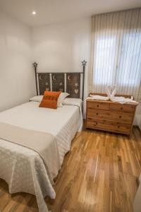 アリカンテにあるSkyline Penthouseのベッドルーム1室(ベッド1台、木製ドレッサー付)