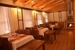 une salle à manger avec des tables, des chaises et une cheminée dans l'établissement Kerpic Evler, à Fethiye