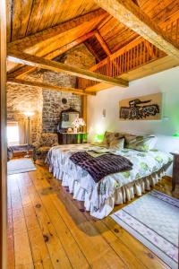 - une chambre avec un lit dans une pièce dotée de plafonds en bois dans l'établissement Auberge Baker, à Chateau Richer