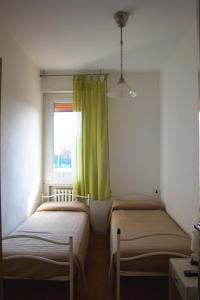 Duas camas num pequeno quarto com uma janela em Appartamento viale pedonale a due passi dal mare em Bellaria-Igea Marina