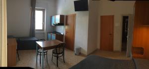a small room with a desk and a table with chairs at Residence Ducale in Rodi Garganico