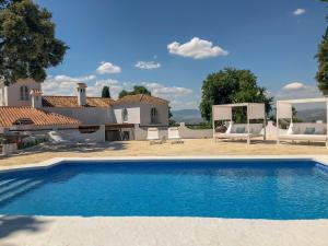 a villa with a swimming pool in front of a house at B&B Casa Luz del Sur, adults only in Alhaurín el Grande