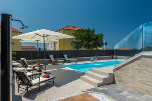 basen z krzesłami i parasolem w obiekcie Villa Franica Zadar w mieście Zadar