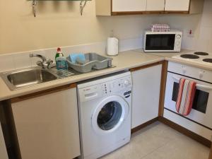 kuchnia z pralką i zlewem w obiekcie One-Bedroom Apartment - Wyvis Free Parking w mieście Inverness