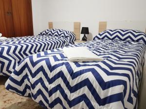 Duas camas num quarto com edredão azul e branco em Apartamento Completo Maravall Centro em Benidorm