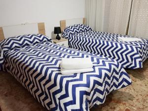 two beds with blue and white sheets in a room at Apartamento Completo Maravall Centro in Benidorm
