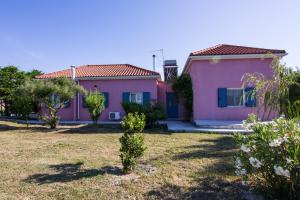 een roze huis met een tuin bij Kefalonia Ammos Villa in Lixouri