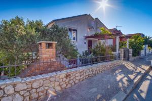 une maison avec un mur en pierre et une clôture dans l'établissement Apartment Borka, à Mali Lošinj