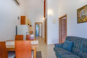 a kitchen and living room with a couch and a table at Apartment Borka in Mali Lošinj +20 photos