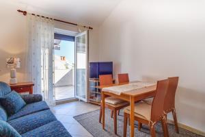 a living room with a table and a blue couch at Apartment Borka in Mali Lošinj