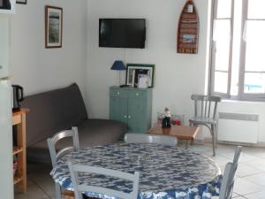 a living room with a table and a couch at la maison de vincente in Arzon