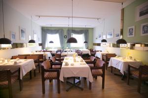 a restaurant with tables and chairs with white table cloth at Rabes Hotel Kiel in Kiel