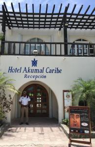 um homem parado em frente a uma recepção de cartuchos de animais de hotel em Hotel Club Akumal Caribe em Akumal