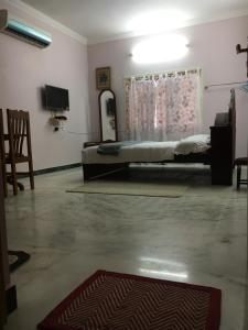 1 dormitorio con cama, ventana y alfombra en Pleasant Stay, en Tiruchchirāppalli