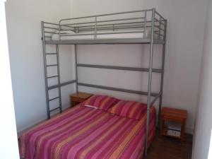 a bedroom with a bunk bed with a striped blanket at la maison de vincente in Arzon