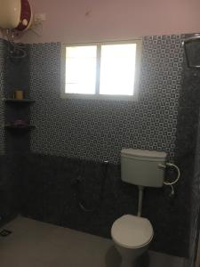 baño con aseo y ventana en Pleasant Stay, en Tiruchchirāppalli