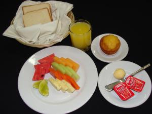 uma mesa com pratos de comida e um copo de sumo de laranja em Hotel Club Akumal Caribe em Akumal