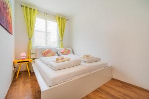 una camera da letto con un letto con lenzuola bianche e una finestra di 10 Min. Downtown - 2 Bedrooms - Parking a Vienna