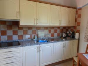 a kitchen with white cabinets and a sink at Villa Mimosa in Moraira
