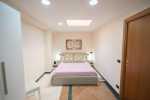 um quarto com uma cama num quarto branco em Al Vecchio Fontanile em Lesina