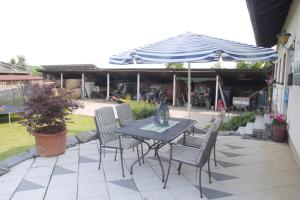 einen Tisch mit Stühlen und einem Sonnenschirm auf einer Terrasse in der Unterkunft Kalles Heimat in Reichartshausen