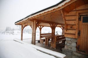 ザコパネにあるWilla Basiaの木造パビリオン(雪の中のピクニックテーブル付)