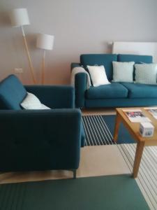 a living room with two blue couches and a coffee table at Domitys La Calliope in Metz +10 photos
