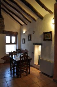 une salle à manger avec une table, des chaises et une cheminée dans l'établissement Casa Rural El Pajar del Portalico, à Letur
