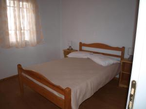 a bedroom with a bed with white sheets and a window at Alatsaria House in Cherronisos
