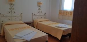 a room with two beds and a window at Residence Spiaggia Bianca in Golfo Aranci