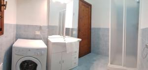 a laundry room with a washing machine and a mirror at Residence Spiaggia Bianca in Golfo Aranci