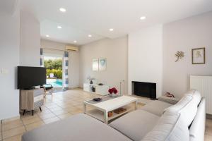 a living room with a couch and a tv at Villa SteMa in Xirokámbion