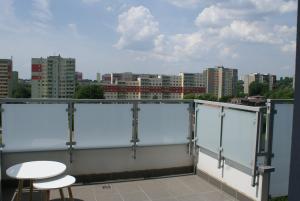 a balcony with two stools and a view of a city at Caroline Street nine in Katowice