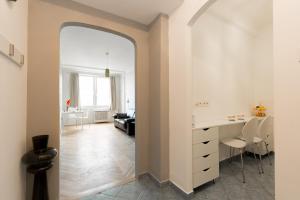 un arco conduce a un soggiorno con cucina e scrivania. di Pamka place a Budapest
